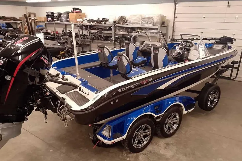 The Image of 2026 Ranger 620FS Cup-Equipped boat in garage, featuring blue and black design with powerful engine. - 0