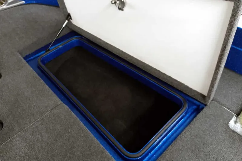 Slide: The Image of Open storage compartment in 2026 Ranger 620FS Cup-Equipped boat, featuring blue trim and gray interior. - 14