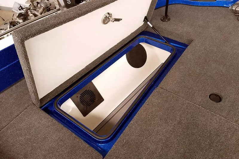 Slide: The Image of Open storage compartment in 2026 Ranger 620FS Cup-Equipped boat, featuring carpeted interior. - 15