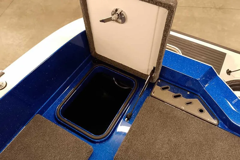 Slide: The Image of 2026 Ranger 620FS Cup-Equipped boat storage compartment with open lid and key. - 40