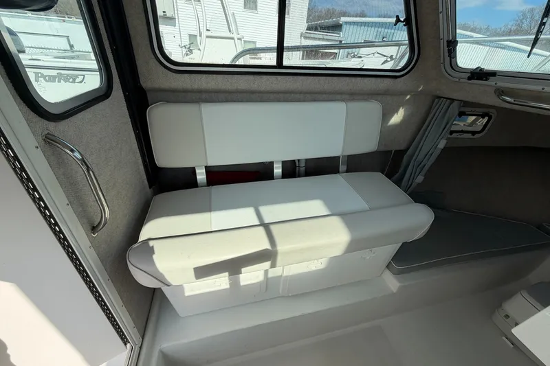 Slide: The Image of Interior of a 2015 Parker 2120 boat featuring a cushioned bench seat. - 10