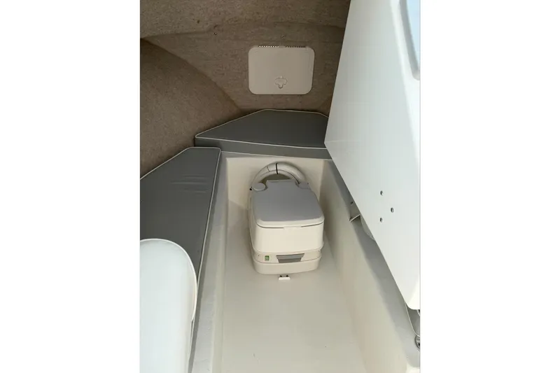 Slide: The Image of Interior of a 2015 Parker 2120 boat featuring a compact portable toilet. - 11