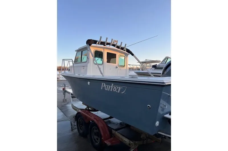 Slide: The Image of 2015 Parker Boats 2120 on trailer, docked under clear blue sky. - 5