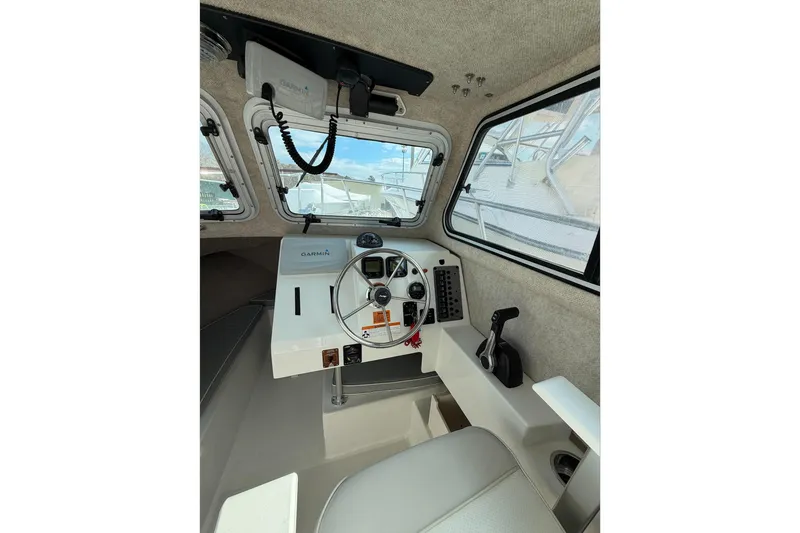 Slide: The Image of Interior of a 2015 Parker 2120 boat with steering wheel and Garmin navigation system. - 8