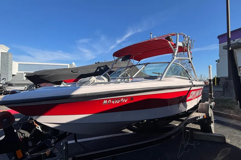 The Image of 2006 Nautique Ski Nautique 206 boat with red and white design on a trailer. - 0