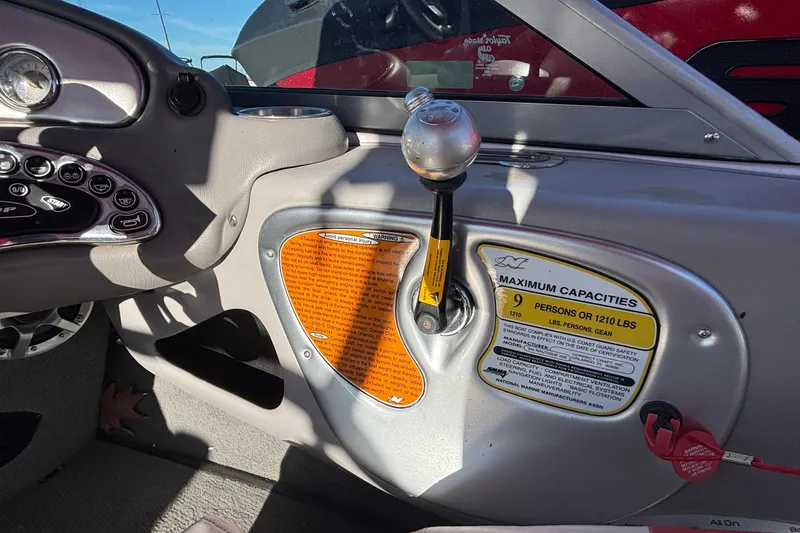 Slide: The Image of 2006 Nautique Ski Nautique 206 dashboard with gear shift and capacity warning labels. - 17