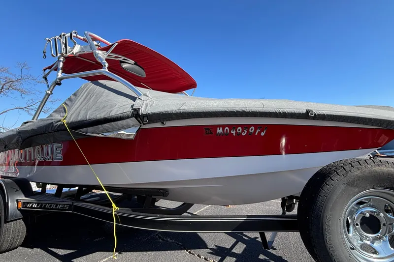 Slide: The Image of 2006 Nautique Ski Nautique 206 boat with red and white design, parked at marina. - 2
