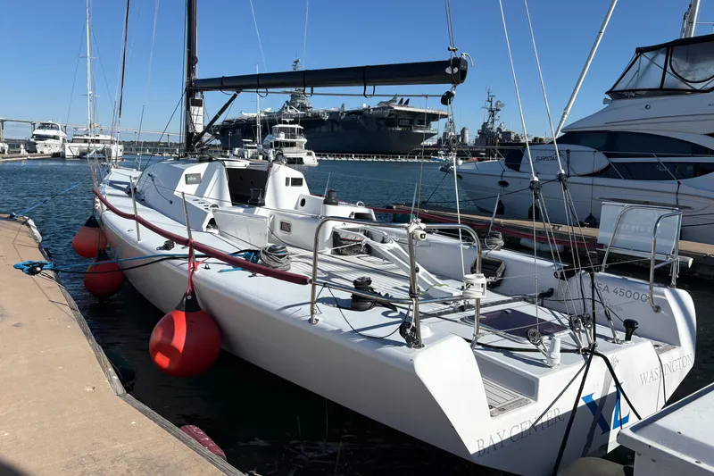 Slide: The Image of Antrim 40 sailboat docked at marina, surrounded by other vessels, clear blue sky. - 2
