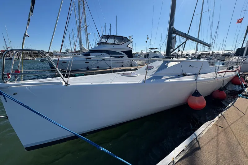 Slide: The Image of Sleek Antrim 40 sailboat docked in marina, surrounded by other vessels. - 3