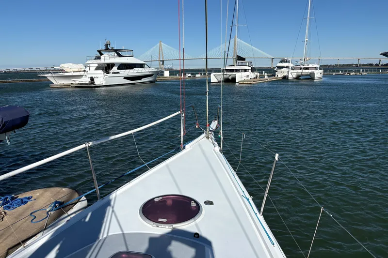 Slide: The Image of Bow view of Antrim 40 sailboat in marina with bridge and yachts in background. - 6