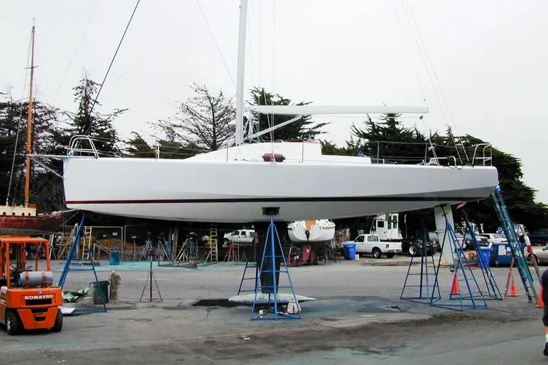 Slide: The Image of Antrim 40 sailboat on stands in a boatyard, surrounded by trees and equipment. - 28