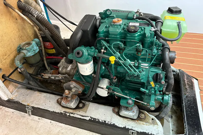 Slide: The Image of Engine compartment of Antrim 40 boat, featuring a green marine engine with hoses and components. - 23