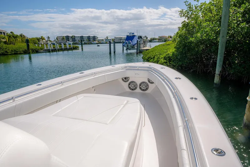 Slide: The Image of 2022 Contender 39 Fisharound boat in scenic marina with lush greenery and clear skies. - 18