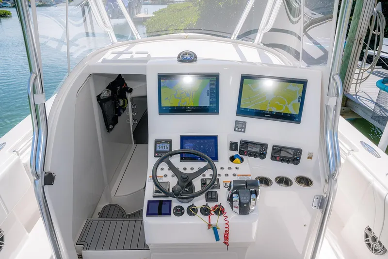 Slide: The Image of 2022 Contender 39 Fisharound boat cockpit with advanced navigation displays and controls. - 38