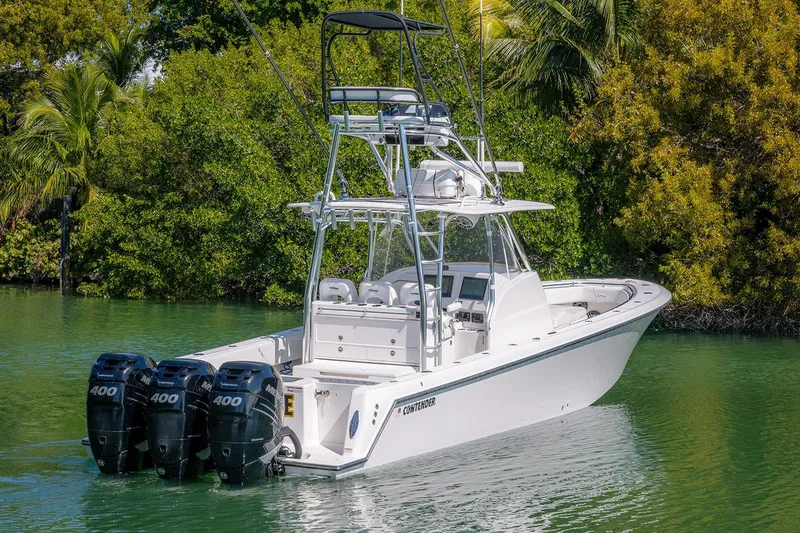 Slide: The Image of 2022 Contender 39 Fisharound boat with triple 400 engines on a serene waterway. - 54