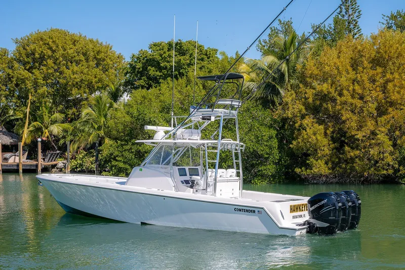 Slide: The Image of 2022 Contender 39 Fisharound boat on a serene waterway, surrounded by lush greenery. - 58