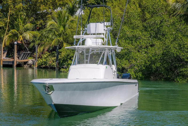 Slide: The Image of 2022 Contender 39 Fisharound boat on serene water, surrounded by lush greenery. - 59