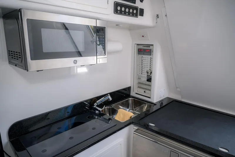 Slide: The Image of Modern kitchen area in 2022 Contender 39 Fisharound boat with microwave and sink. - 9