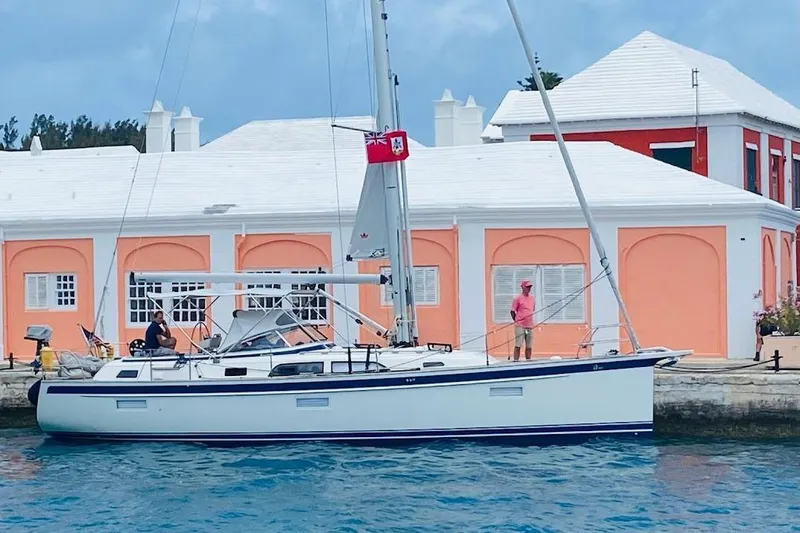 The Image of 2021 Hallberg-Rassy 40C yacht docked by pastel-colored buildings. - 0