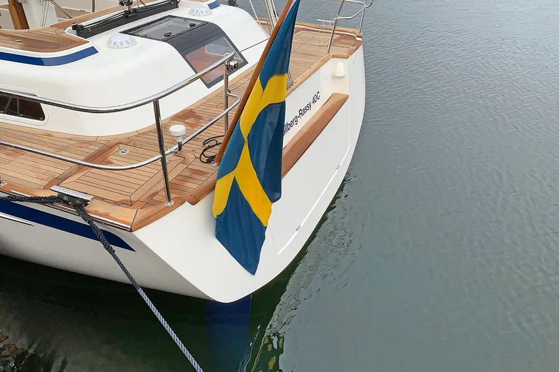 Slide: The Image of Hallberg-Rassy 40C sailboat, 2021 model, with Swedish flag, docked on calm water. - 16