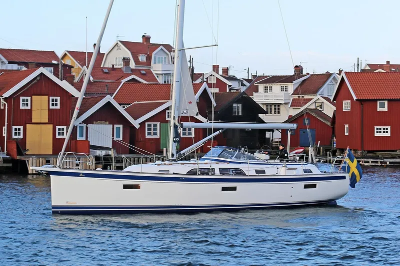 Slide: The Image of 2021 Hallberg-Rassy 40C yacht sailing near red coastal houses. - 17