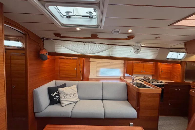 Slide: The Image of Luxurious 2021 Hallberg-Rassy 40C yacht interior with cozy seating and modern kitchen. - 26