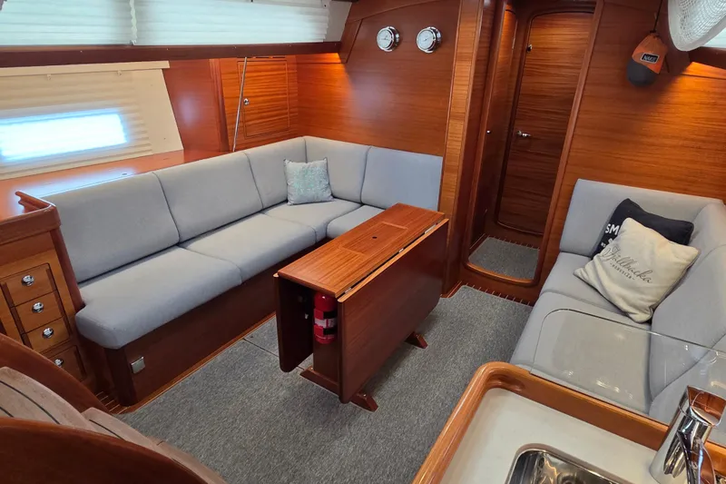 Slide: The Image of Interior of 2021 Hallberg-Rassy 40C yacht with elegant wood finish and cozy seating area. - 28