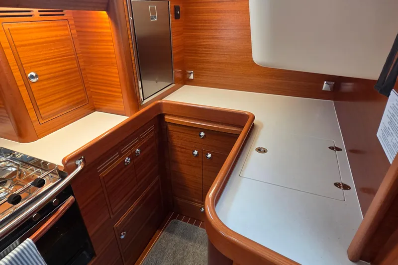 Slide: The Image of Luxurious 2021 Hallberg-Rassy 40C yacht kitchen with elegant wood cabinetry and modern appliances. - 29