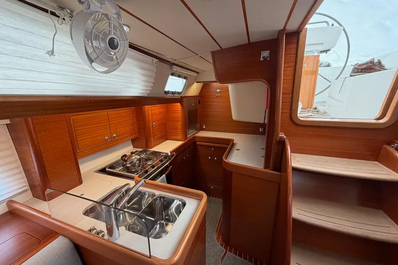 Slide: The Image of Interior of 2021 Hallberg-Rassy 40C yacht, featuring a modern kitchen and wooden cabinetry. - 30