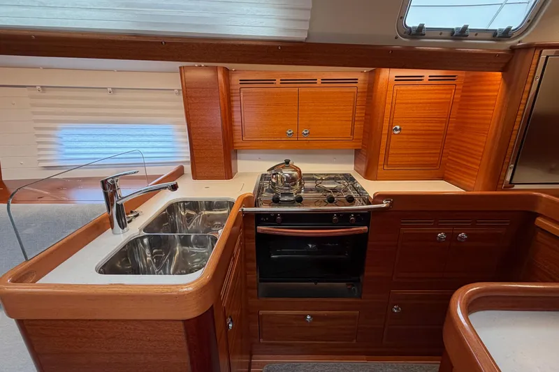 Slide: The Image of Luxurious 2021 Hallberg-Rassy 40C yacht kitchen with wooden cabinetry and modern appliances. - 31
