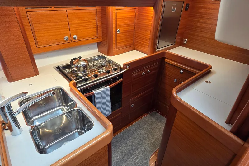 Slide: The Image of Luxurious 2021 Hallberg-Rassy 40C yacht kitchen with wood cabinetry and modern appliances. - 32
