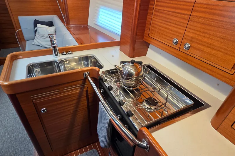 Slide: The Image of Luxurious 2021 Hallberg-Rassy 40C yacht kitchen with stove, sink, and wooden cabinetry. - 33