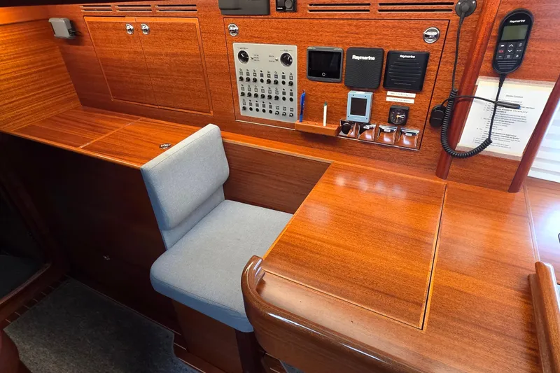 Slide: The Image of Navigation station of 2021 Hallberg-Rassy 40C yacht with control panel and seating. - 34