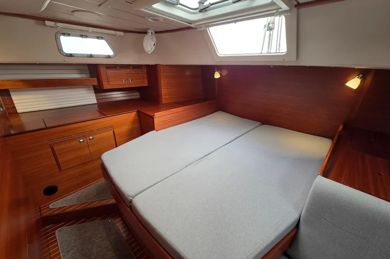Slide: The Image of Luxurious 2021 Hallberg-Rassy 40C yacht cabin with elegant wood finish and cozy bedding. - 37