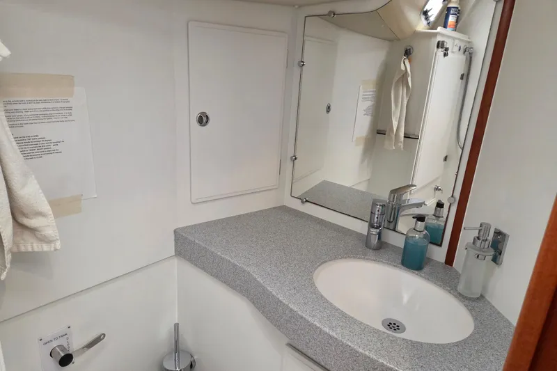 Slide: The Image of Modern bathroom in 2021 Hallberg-Rassy 40C yacht with sink, mirror, and toiletries. - 43