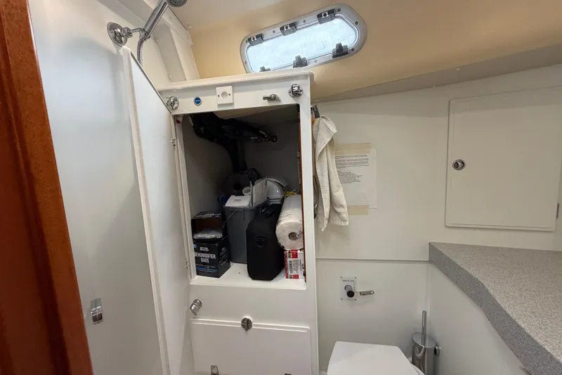 Slide: The Image of Bathroom storage area in a 2021 Hallberg-Rassy 40C yacht, featuring organized shelves and essentials. - 46