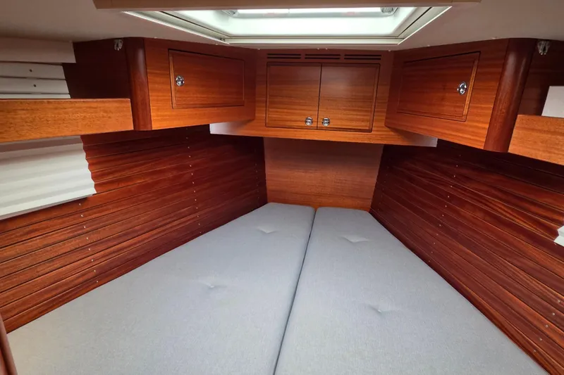 Slide: The Image of Luxurious 2021 Hallberg-Rassy 40C yacht cabin with elegant wood finish and cozy bedding. - 47