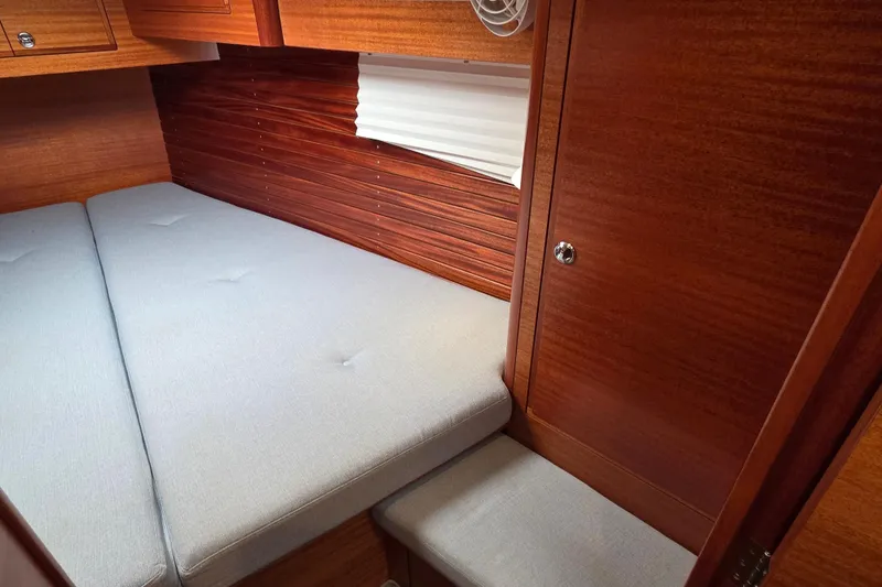 Slide: The Image of 2021 Hallberg-Rassy 40C cabin interior with wooden finish and cushioned bed. - 50