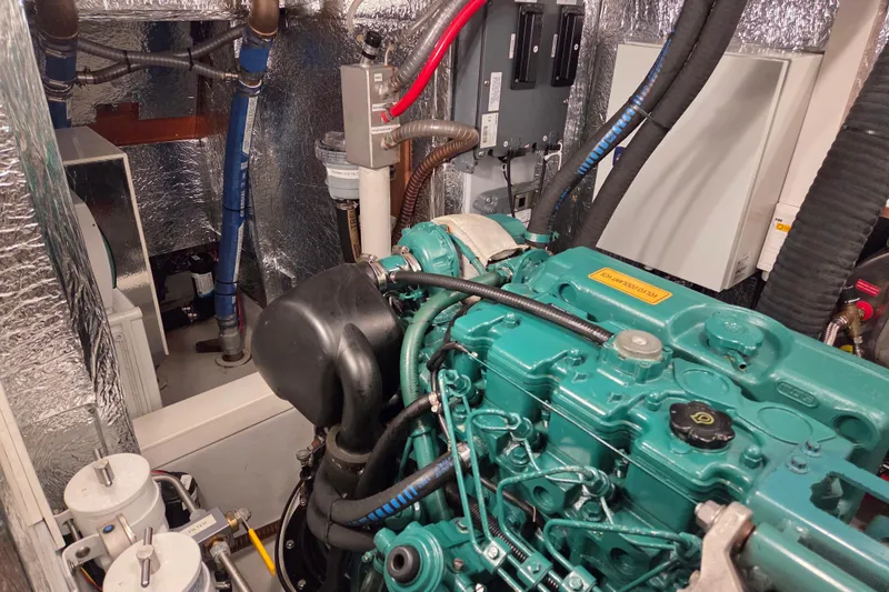 Slide: The Image of Engine room of a 2021 Hallberg-Rassy 40C yacht, featuring a green engine and insulated walls. - 52