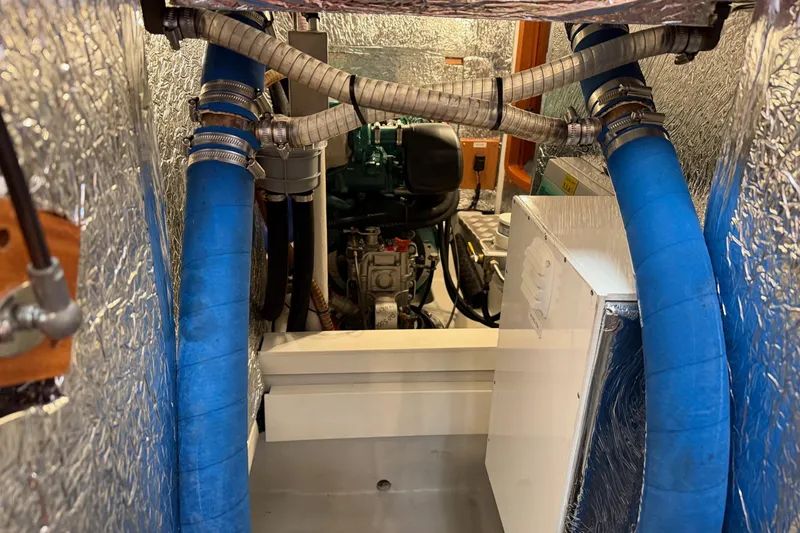Slide: The Image of Engine room of 2021 Hallberg-Rassy 40C yacht with blue hoses and insulation. - 53