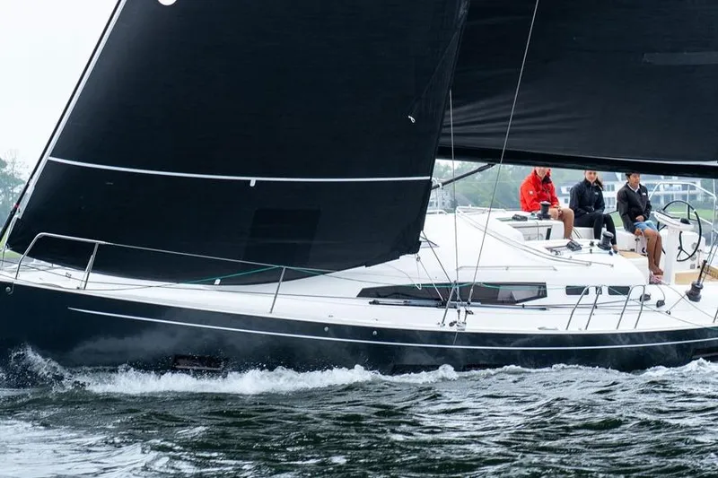 Slide: The Image of 2026 J Boats J/40 sailing with crew, featuring sleek black sails and modern design. - 7