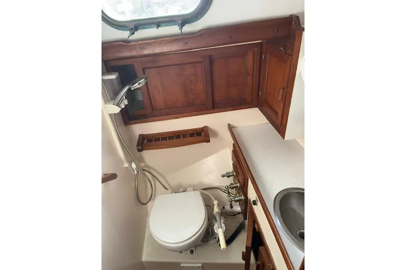 Slide: The Image of 1978 Rafiki 35 boat bathroom with wooden cabinets, toilet, and sink. - 10