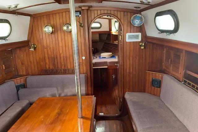 Slide: The Image of Interior of a 1978 Rafiki 35 sailboat with wooden paneling and cozy seating. - 11