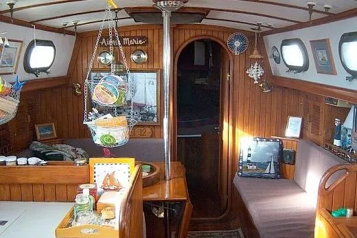 Slide: The Image of Cozy 1978 Rafiki 35 sailboat interior with wooden paneling and nautical decor. - 12