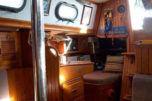 Slide: The Image of Cozy 1978 Rafiki 35 sailboat interior with wood paneling and nautical decor. - 15