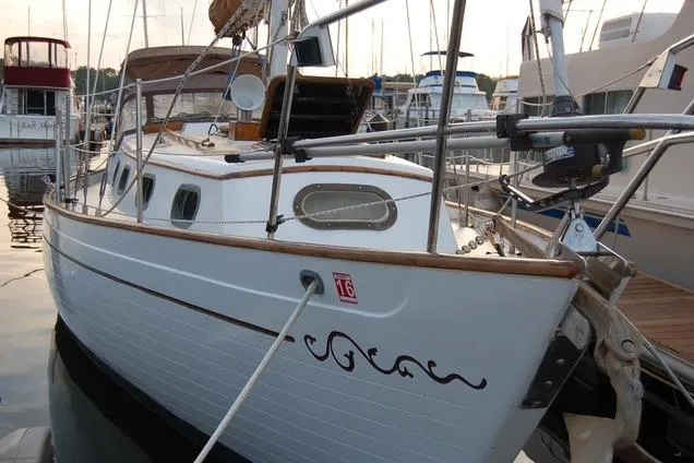 Slide: The Image of 1978 Rafiki 35 sailboat docked in a marina, showcasing classic design and wooden accents. - 3