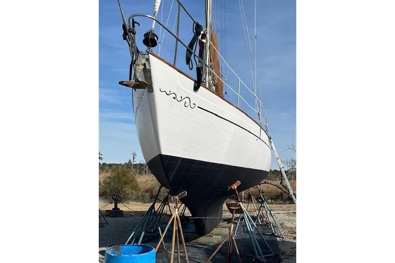 Slide: The Image of 1978 Rafiki 35 sailboat on stands, white hull, blue sky background. - 5