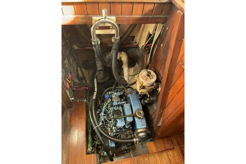 Slide: The Image of 1978 Rafiki 35 engine compartment with visible blue engine and wooden surroundings. - 9