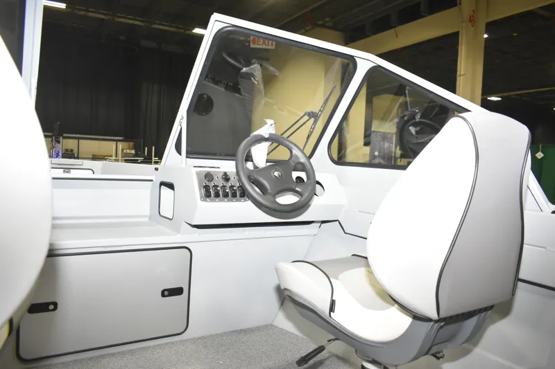 Slide: The Image of Interior of 2026 KingFisher 16 Falcon boat, featuring steering wheel and comfortable seating. - 11