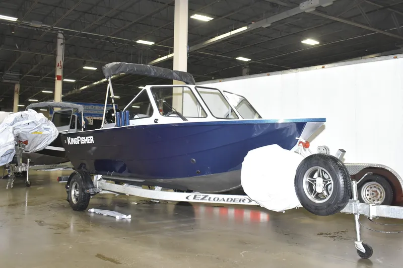 Slide: The Image of 2026 KingFisher 16 Falcon boat displayed indoors with trailer and equipment. - 3
